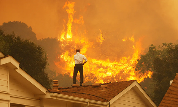 美國加州卡馬里奧，屋頂上的一名男子看著即將逼近的大火。